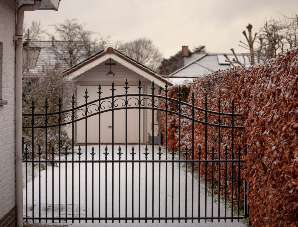 Hoftor aus Schmiedeeisen mit Rundbogen vor einem Haus