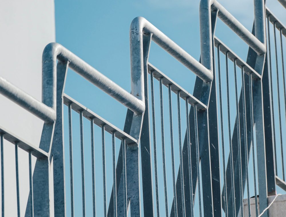 Verzinkte Stahlgitter mit senkrechten Stäben vor blauem Himmel
