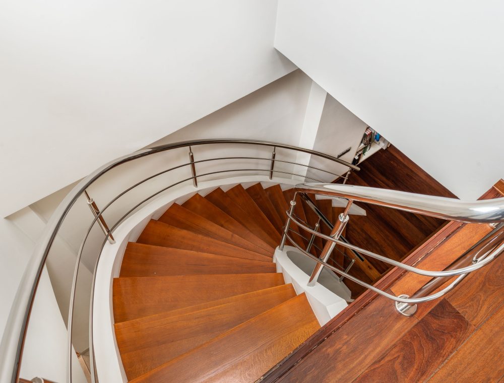 Wendeltreppe mit Holzstufen und Edelstahl-Handlauf von oben